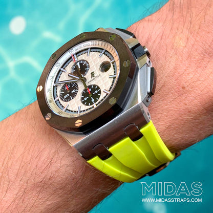 Angled wrist view of an Audemars Piguet Royal Oak Offshore 44mm with an acid lime green replacement rubber strap beside a swimming pool.