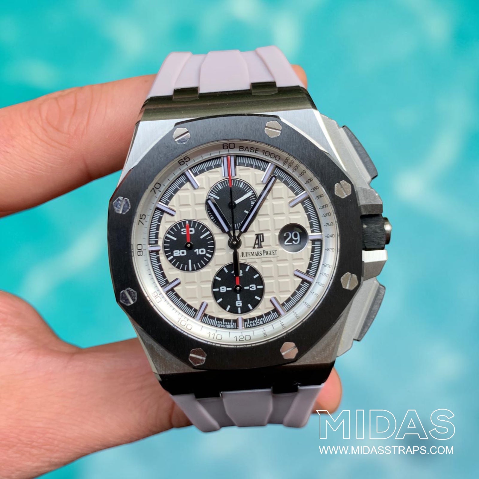 AP Royal Oak Offshore 26400 fitted with a blush pink grey replacement rubber strap in a hand-held lifestyle photograph.