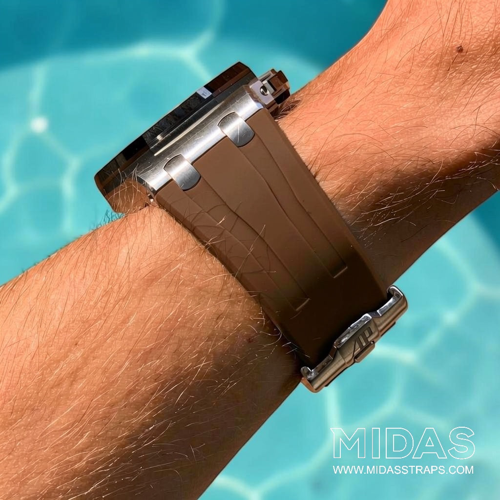 Brown OEM replacement rubber strap fitted to an Audemars Piguet Royal Oak Offshore 44mm watch on wrist beside a swimming pool.