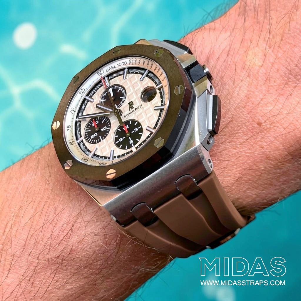 AP Royal Oak Offshore 26400 with brown rubber replacement strap worn on wrist in bright outdoor poolside setting.