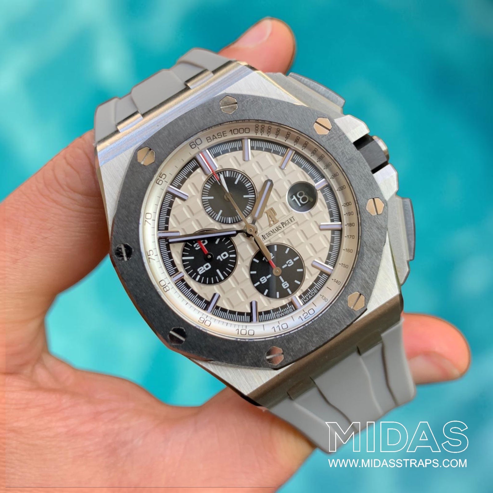 AP Royal Oak Offshore 26400 fitted with a grey replacement rubber strap in a hand-held lifestyle photograph.