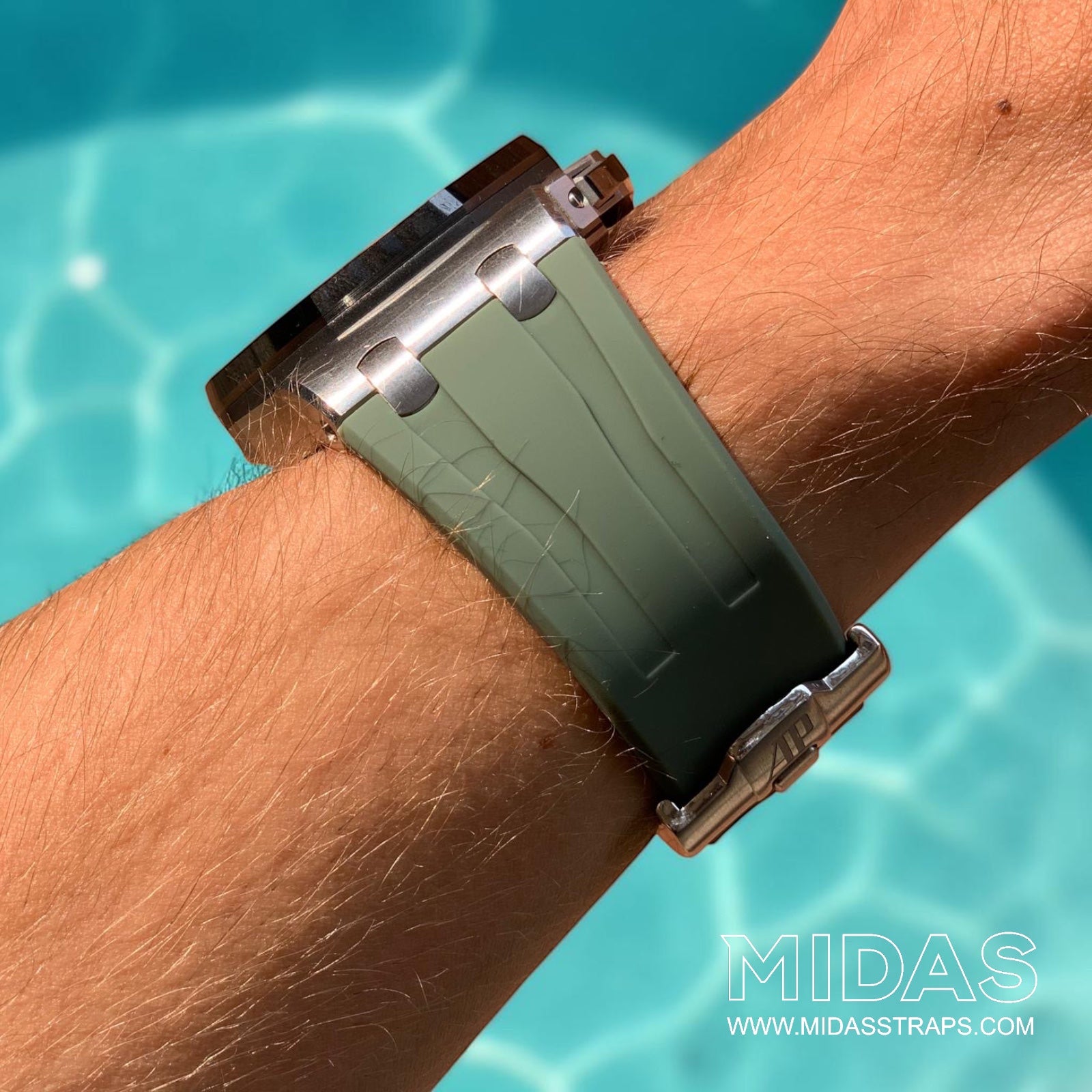 Side profile of a khaki green replacement rubber strap fitted to an Audemars Piguet Royal Oak Offshore 44mm watch on wrist beside a swimming pool.