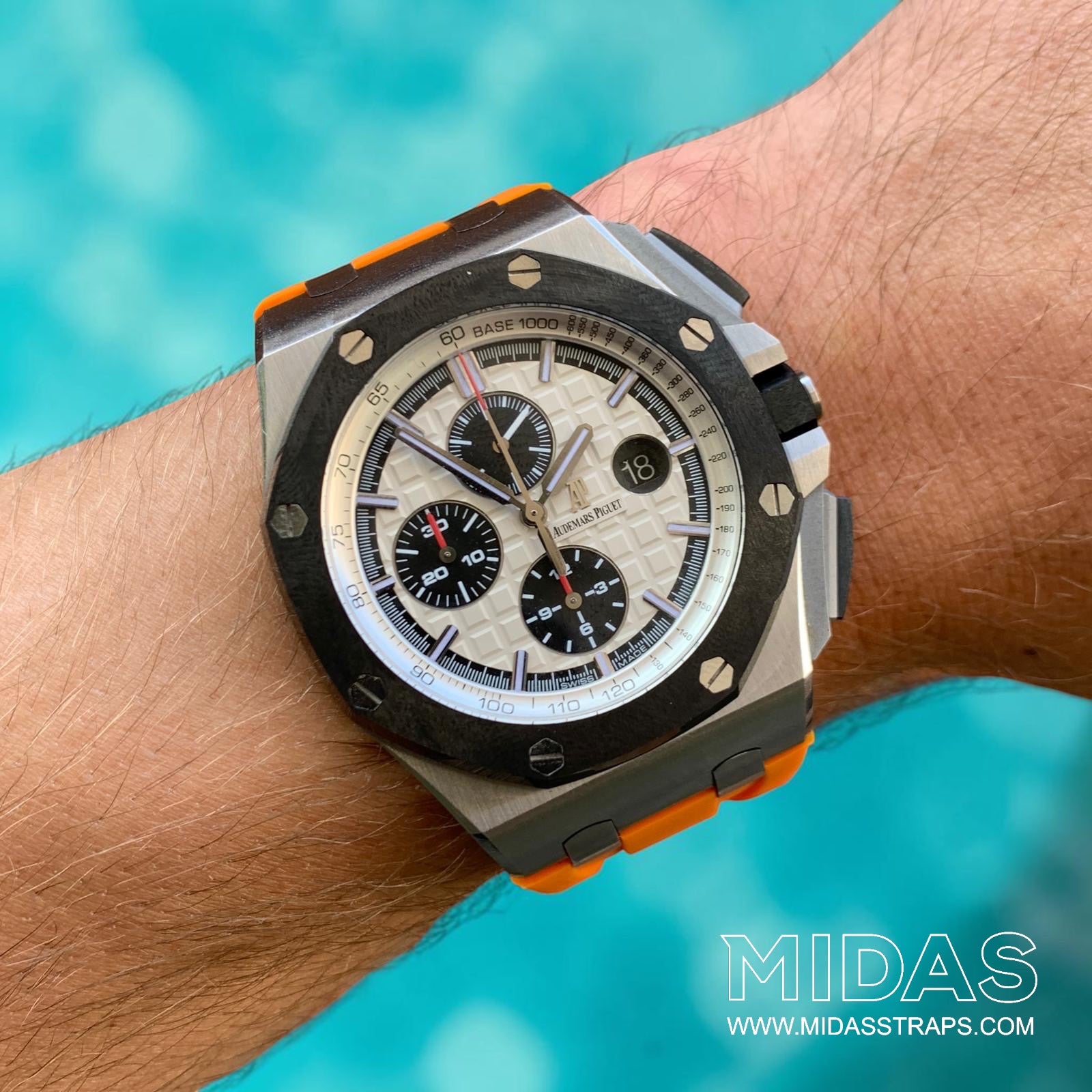 Orange replacement rubber strap fitted to an AP Royal Oak Offshore 26400 in an outdoor lifestyle wrist photograph.