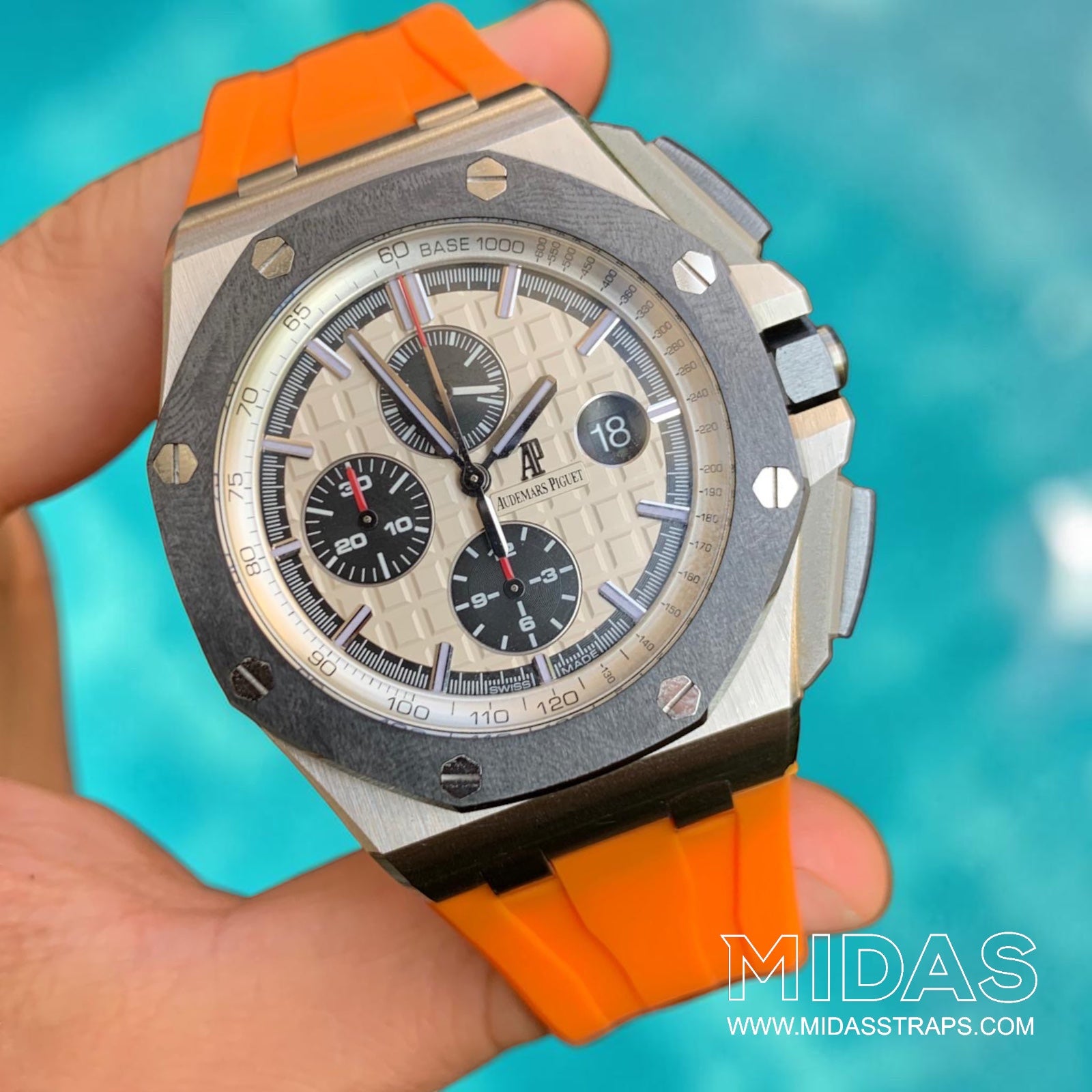 AP Royal Oak Offshore 26400 fitted with an orange replacement rubber strap in a hand-held lifestyle photograph.