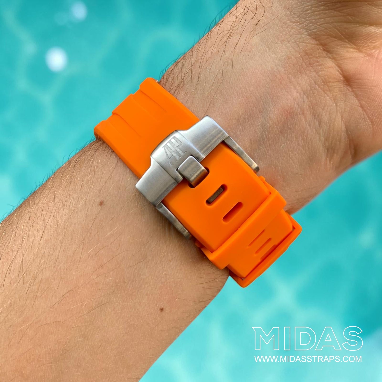 Close-up of an orange replacement rubber strap and clasp fitted to an Audemars Piguet Royal Oak Offshore watch on wrist.