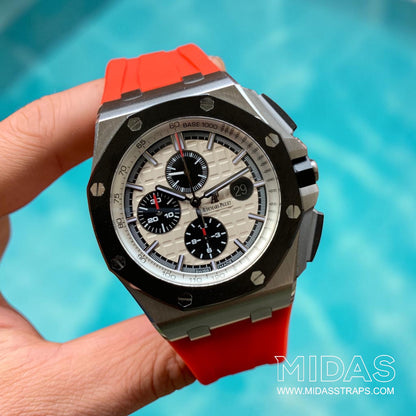 AP Royal Oak Offshore 26400 fitted with a red replacement rubber strap in a hand-held lifestyle photograph.