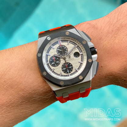 Red replacement rubber strap fitted to an Audemars Piguet Royal Oak Offshore 44mm watch on wrist in an outdoor lifestyle shot.