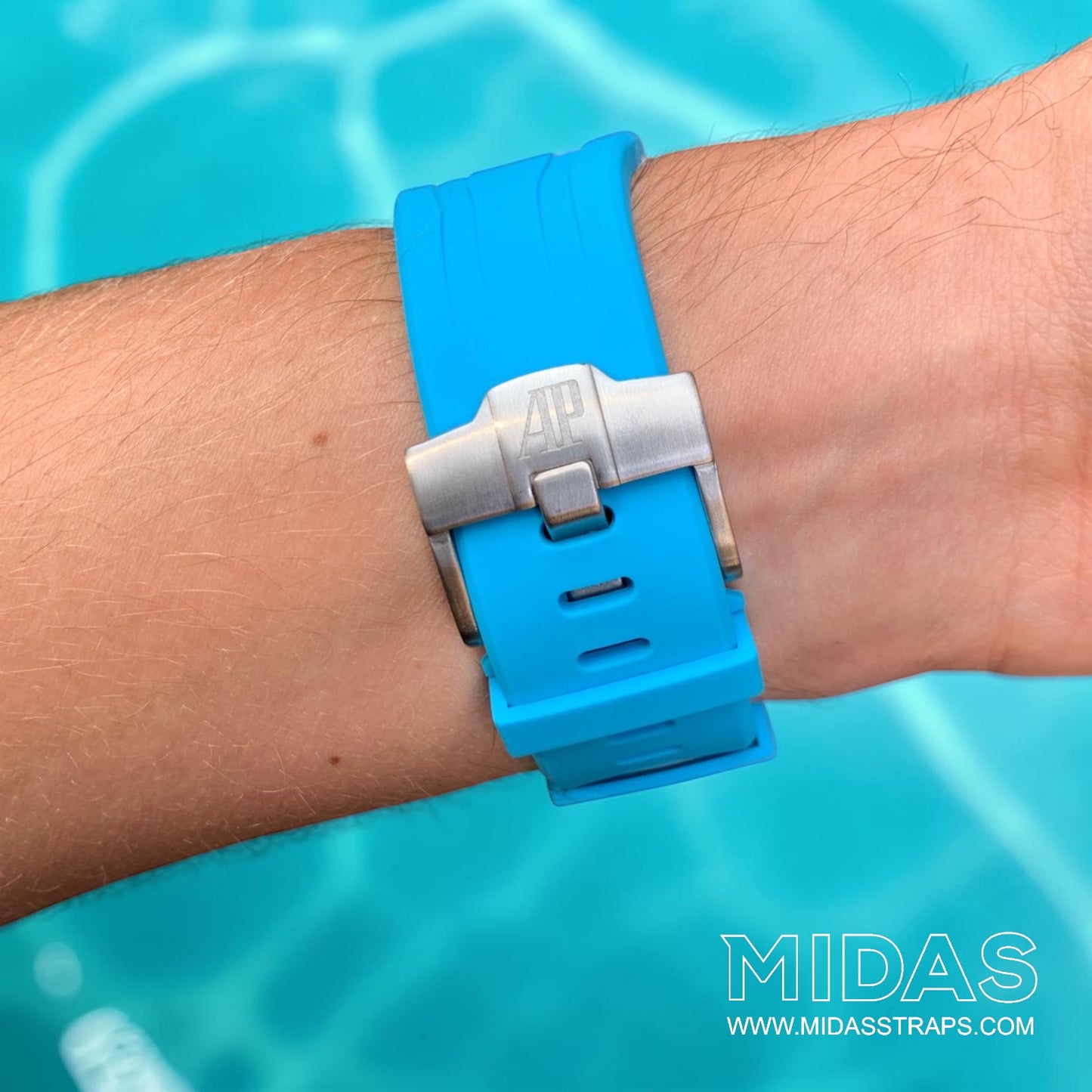 Close-up of a light blue replacement rubber strap and clasp fitted to an Audemars Piguet Royal Oak Offshore watch on wrist.