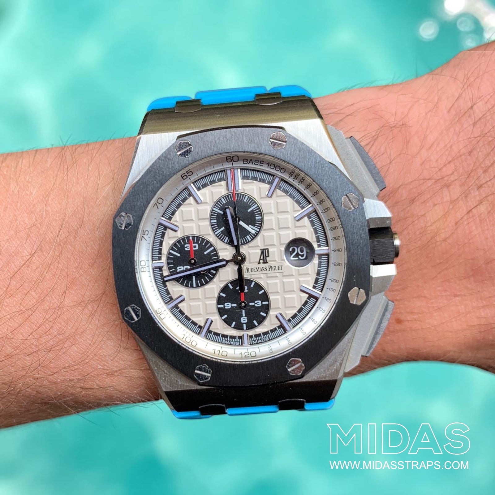 Audemars Piguet Royal Oak Offshore 44mm fitted with a light blue replacement rubber strap in a poolside lifestyle photograph.