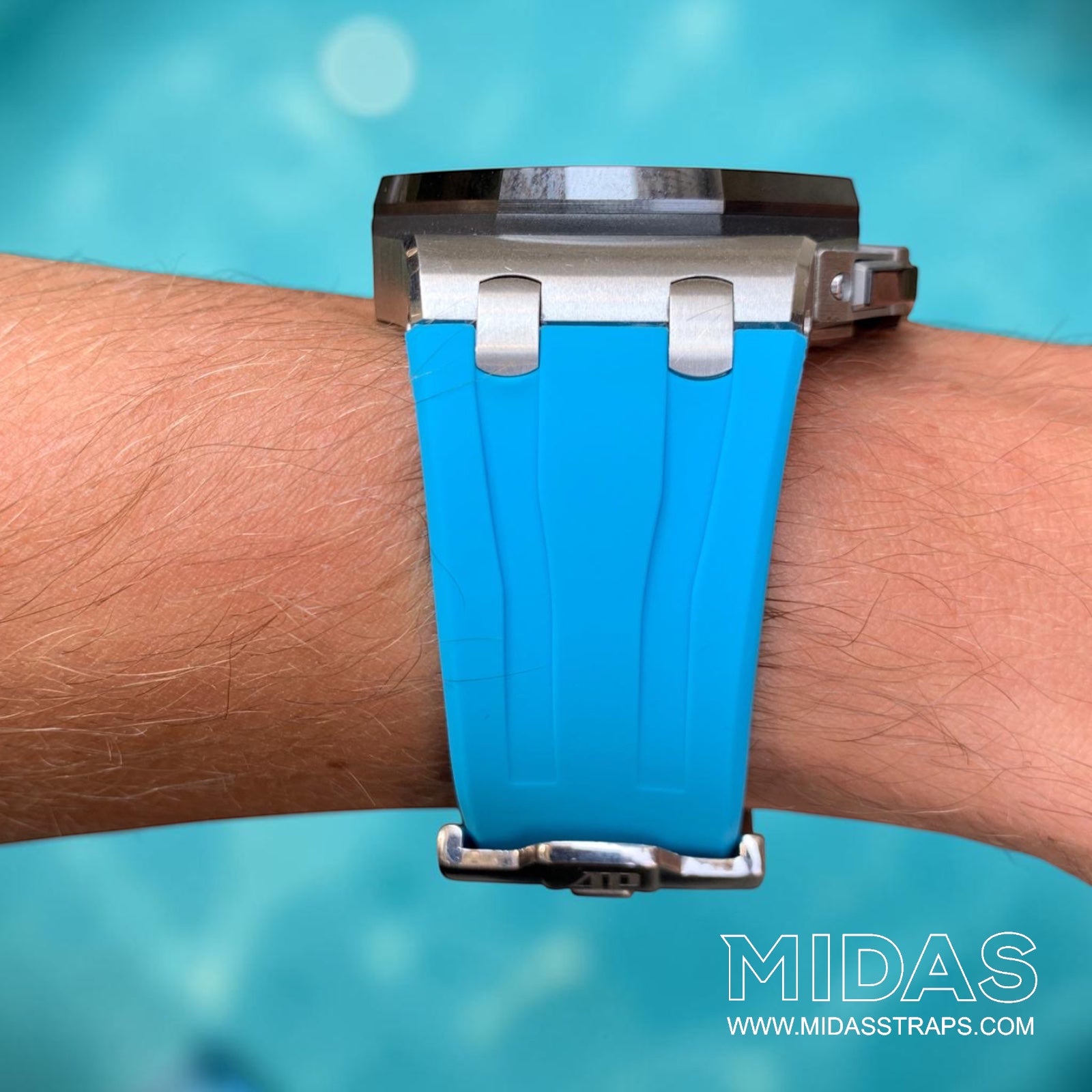 Front view of a light blue replacement rubber strap fitted to an Audemars Piguet Royal Oak Offshore 44mm watch on wrist beside a swimming pool.