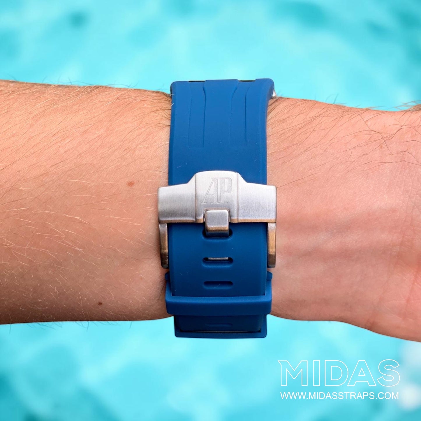 Close-up of a royal navy blue replacement rubber strap and clasp fitted to an Audemars Piguet Royal Oak Offshore watch on wrist.