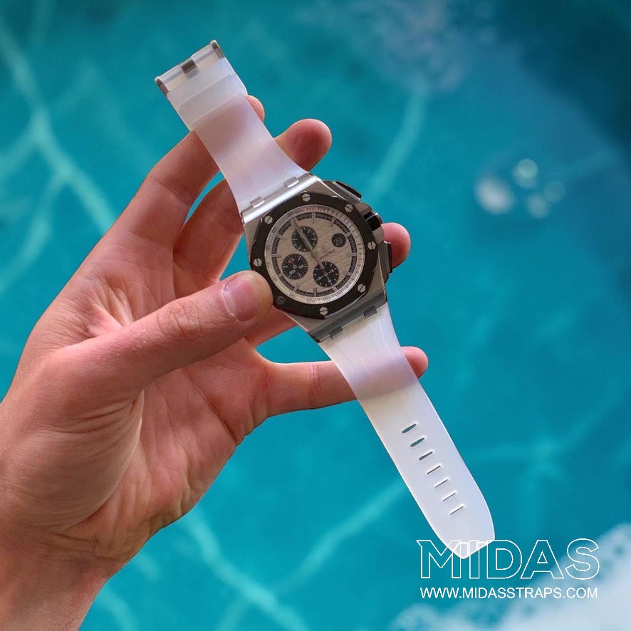 Hand-held Audemars Piguet Royal Oak Offshore 26400 fitted with a transparent clear replacement rubber strap in a poolside lifestyle photograph.